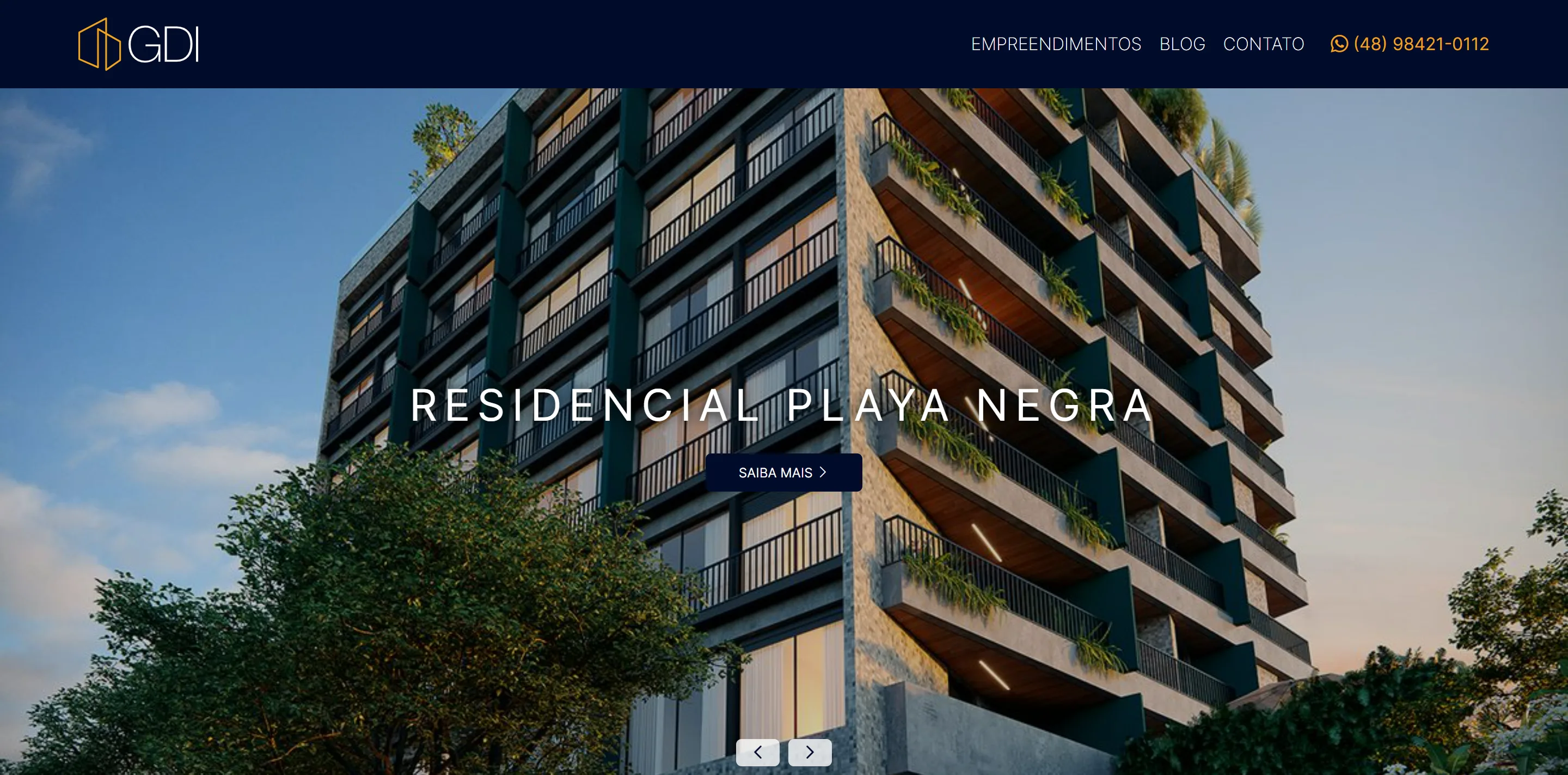 Topo da página inicial do site da GDI Empreendimentos em desktop: o cabeçalho e o hero em slider, com a fotografia do Residencial Playa Negra e o botão Saiba mais.